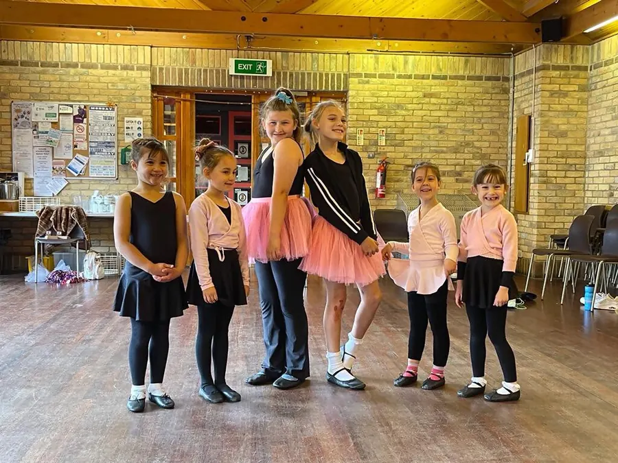 Younger pupils in tutus with their teachers in the Harlow studio