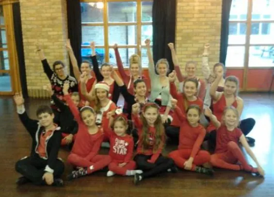 Freestyle and disco pupils in red costumes performing on stage in Harlow